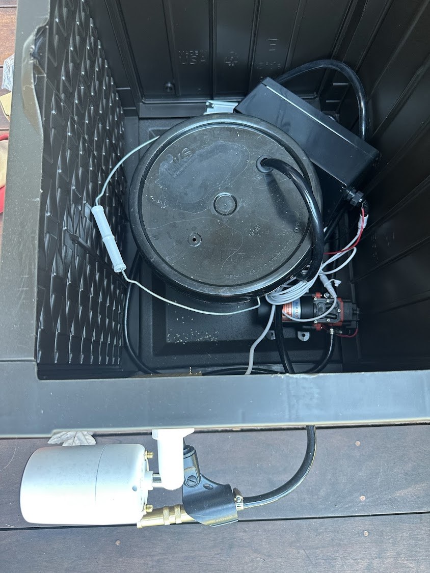 Inside the sprayer bench: bucket, pump and hose